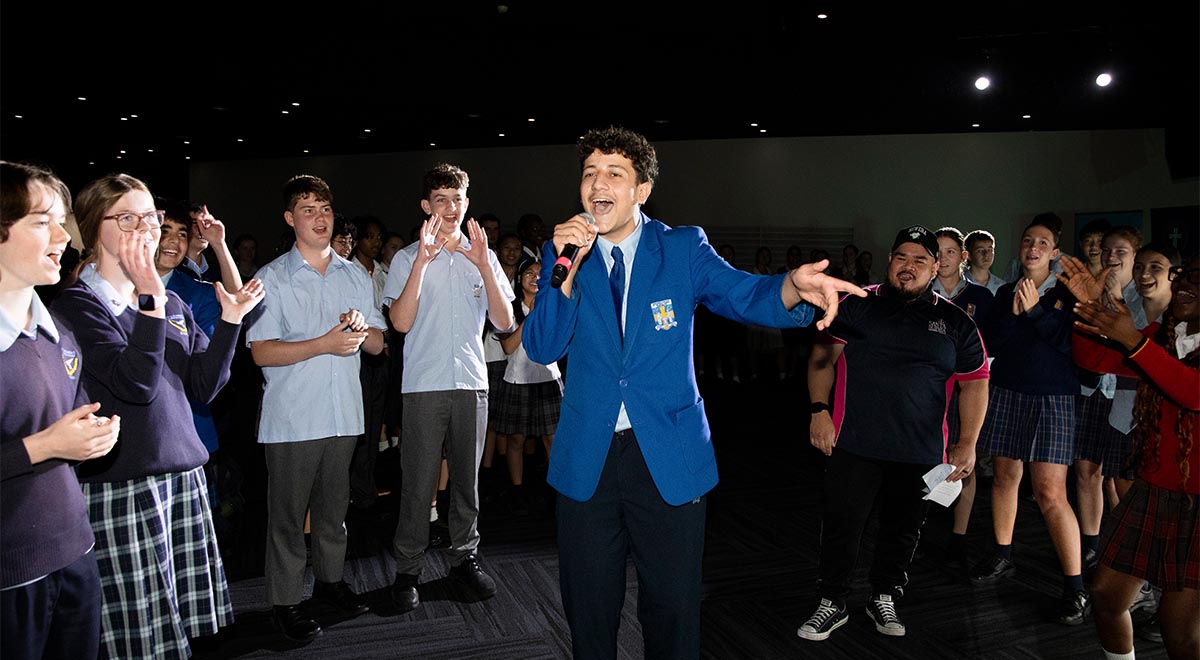 Very happy Gilroy Catholic College student talking into microphone